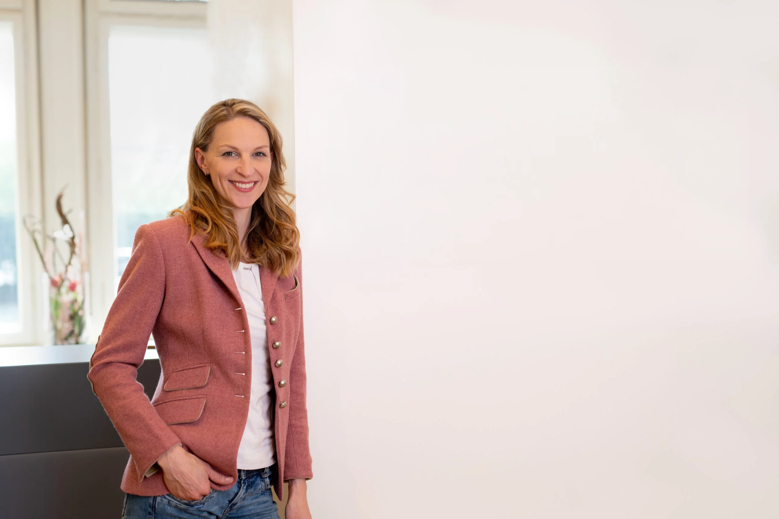 Dr- Eva Hesser Dr. Eva Hesse steht lächelnd in ihrer Praxis